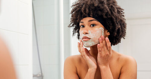 woman washing her face to avoid oily skin