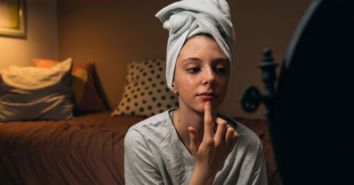 teenager applying skincare products